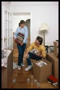 Couple packing books and wrapping items during a move