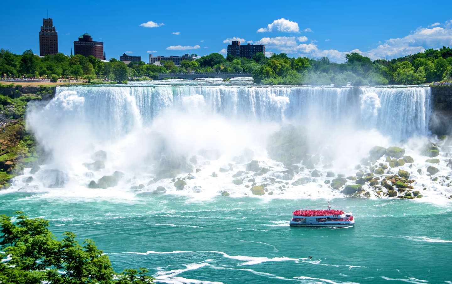 Boat approaching the American Falls at Niagara Falls on a sunny day.