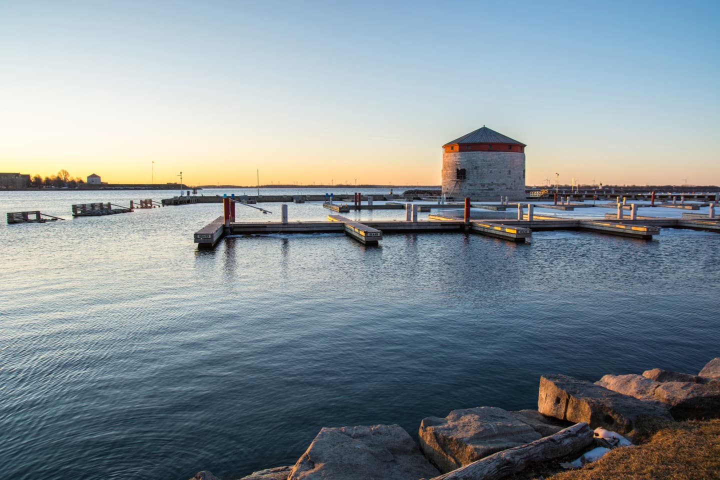 Kingston Ontario waterfront at sunset with historic Martello tower and docks