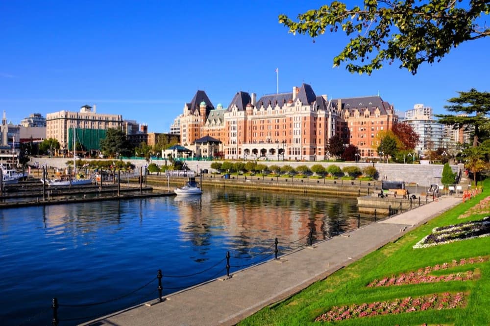 View of the Empress Hotel and Inner Harbour in Victoria on a sunny day.