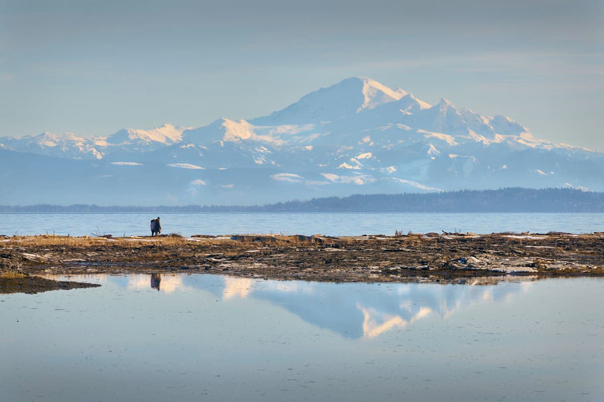 Snow-capped mountain view from Delta, British Columbia, with reflections in water